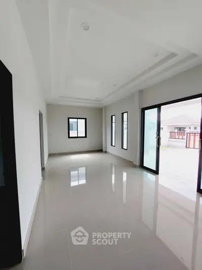 Spacious modern living room with large windows and sliding doors for natural light