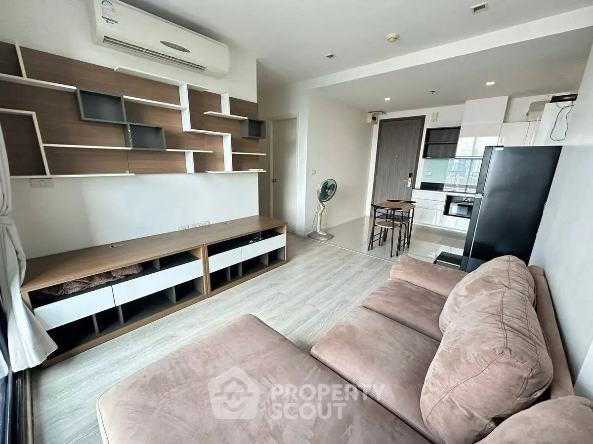 Modern living room with stylish shelving and cozy sofa in open layout apartment.