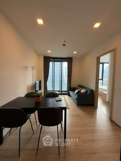 Modern living room with dining area and large windows in a stylish apartment.