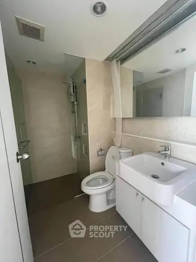 Modern bathroom with glass shower and sleek white fixtures