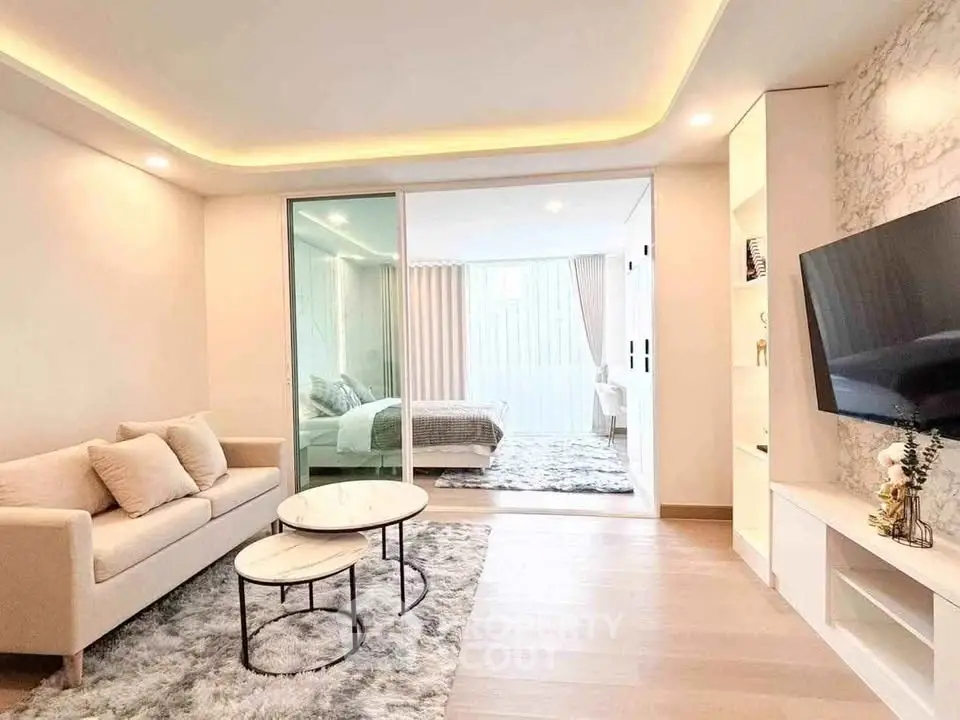 Modern living room with elegant decor and open view to bedroom