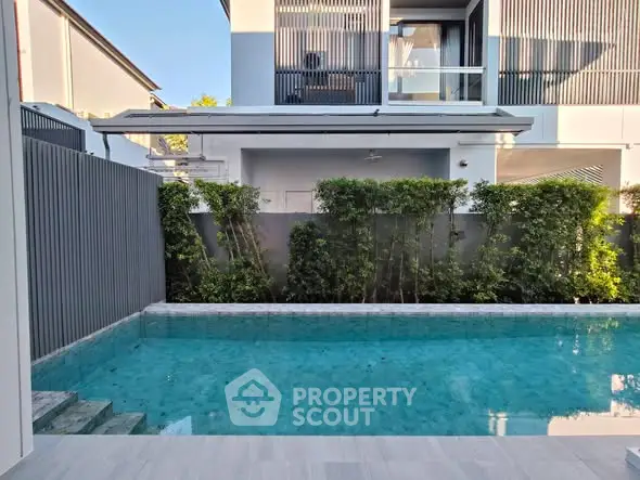 Luxurious modern home with private pool and lush greenery, perfect for relaxation and entertainment.