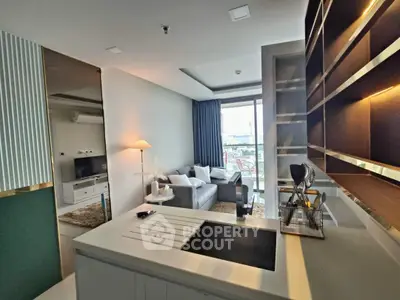 Modern living room with open kitchen and stylish decor in a high-rise apartment.