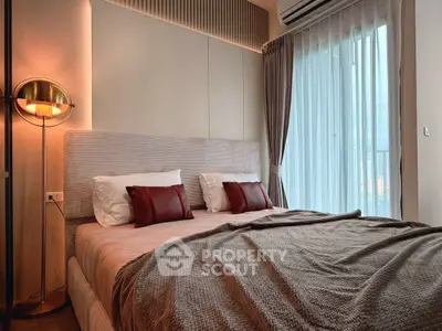 Luxurious bedroom with modern decor and large window offering natural light.
