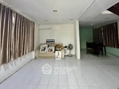 Spacious living area with tiled flooring and large windows, perfect for customization.