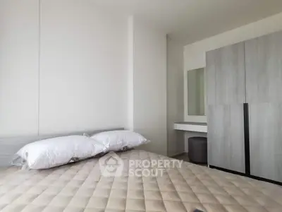 Modern minimalist bedroom with sleek wardrobe and cozy bed setup