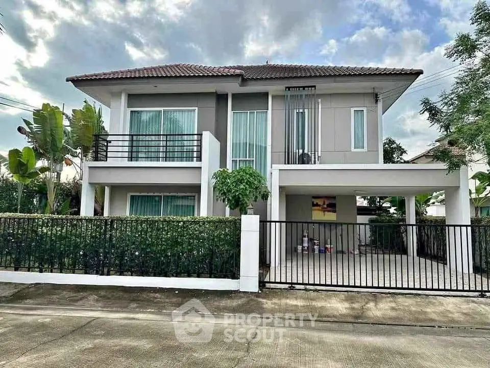 Stunning two-story modern house with lush greenery and spacious driveway.