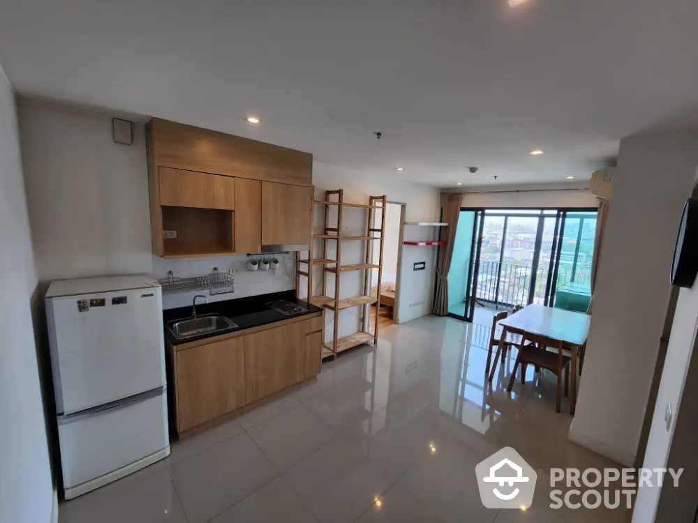 Modern open-layout kitchen and dining area with balcony view