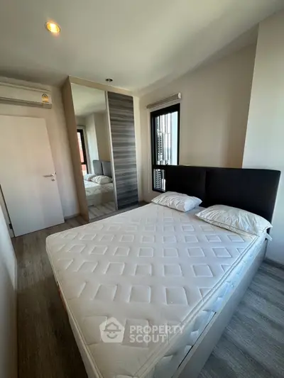 Modern bedroom with stylish decor and large mirror wardrobe in a contemporary apartment.