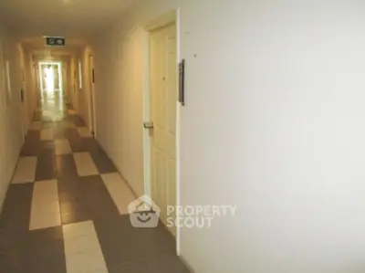 Spacious apartment hallway with modern tile flooring and bright lighting.