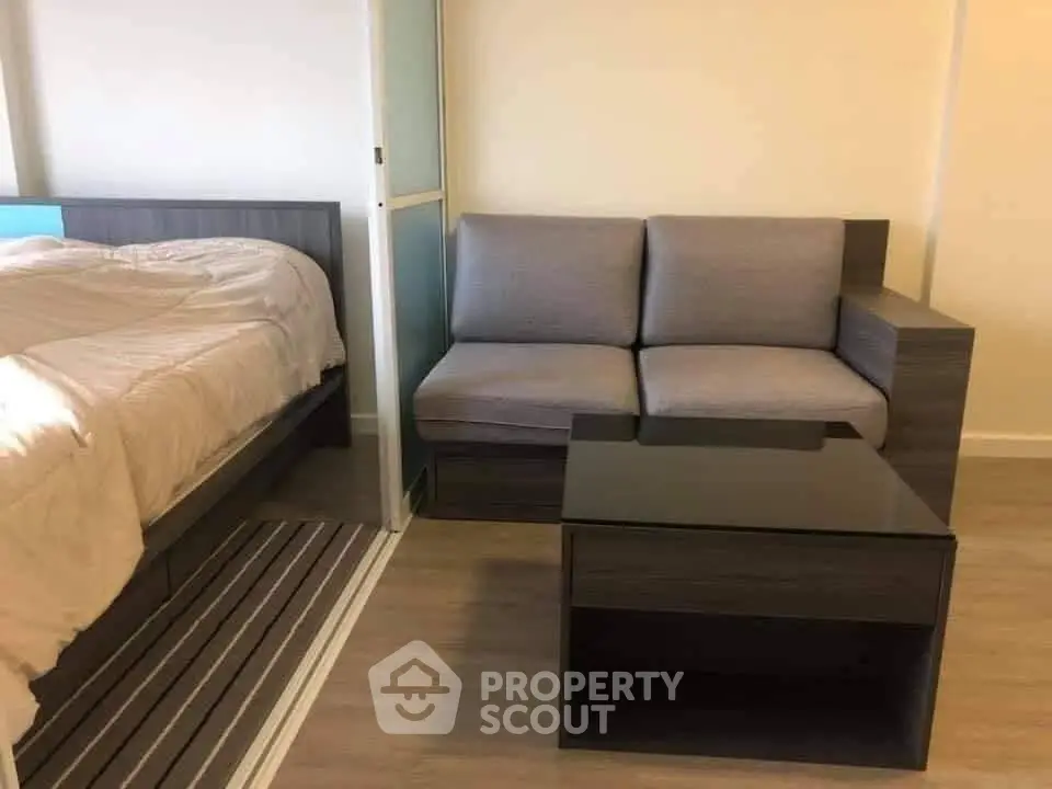 Modern studio apartment with cozy bed and stylish sofa in compact living space.