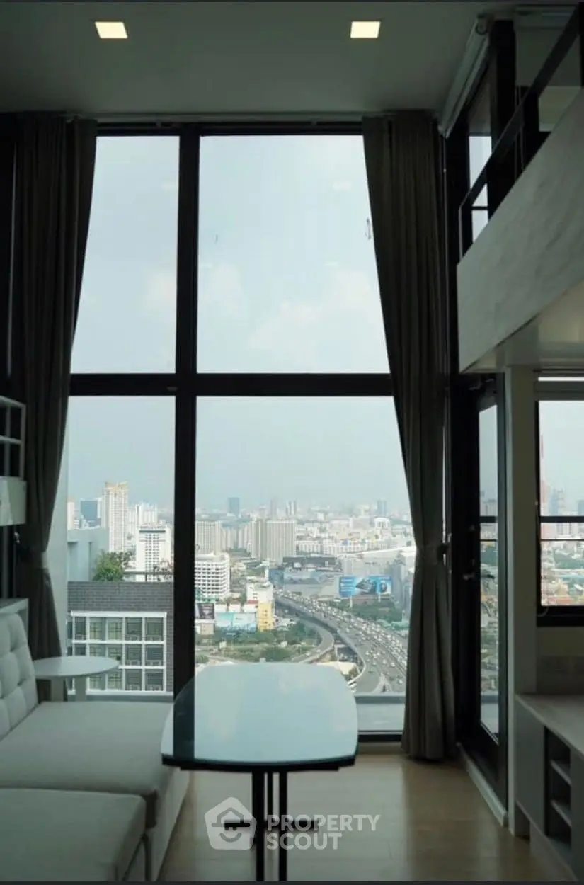 Stunning high-rise living room with floor-to-ceiling windows offering panoramic city views.