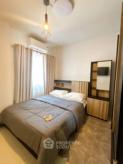 Cozy bedroom with modern decor and ample natural light, featuring a stylish bed and elegant furnishings.