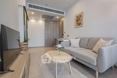 Modern living room with stylish furniture and decor, featuring a cozy sofa and sleek TV setup.