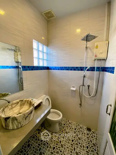 Modern bathroom with stylish stone sink and pebble tile flooring