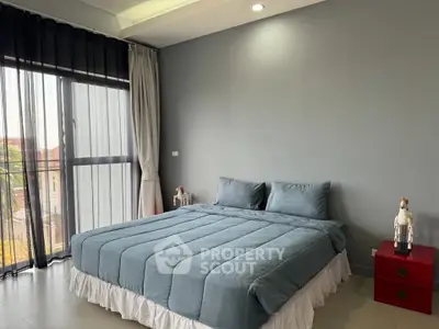 Spacious bedroom with large window and modern decor