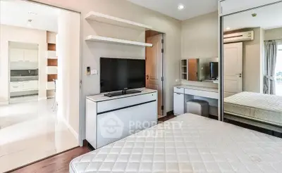 Modern bedroom with TV and mirrored closet in stylish apartment