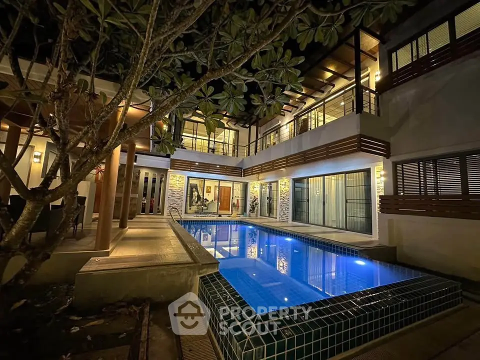 Luxurious modern villa with illuminated pool and elegant architecture at night