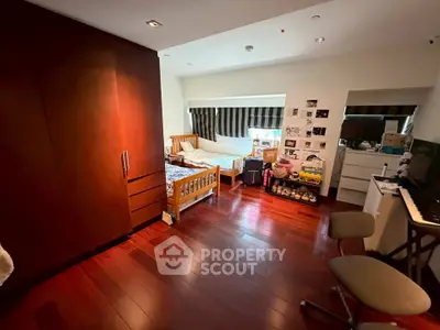 Spacious bedroom with wooden flooring and ample natural light, featuring twin beds and a cozy ambiance.
