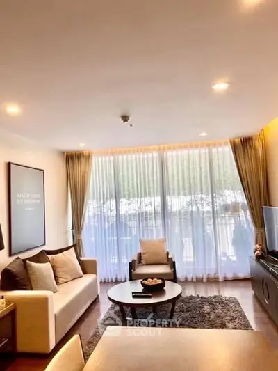 Spacious living room with modern decor and large windows offering natural light.