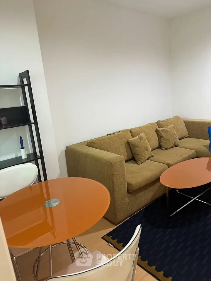 Cozy living room with modern orange tables and comfortable sofa, perfect for relaxation.