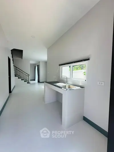 Modern kitchen with sleek design and ample natural light in a contemporary home.