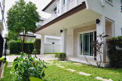 Charming two-story house with lush garden and spacious patio, perfect for family living.