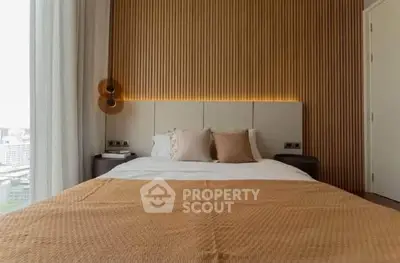 Luxurious bedroom with modern design and city view, featuring elegant lighting and cozy bedding.