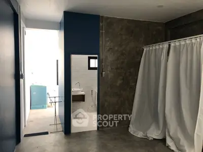 Modern industrial-style interior with concrete walls and minimalist bathroom.