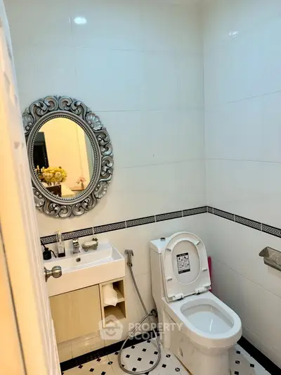Elegant bathroom with ornate mirror and modern fixtures in a stylish real estate property.