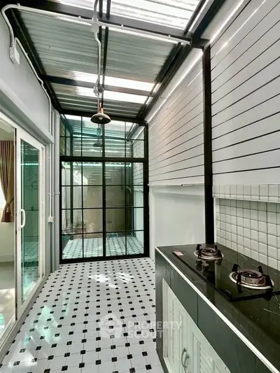 Modern kitchen with sleek gas stove and stylish tiled flooring in a bright, airy space.