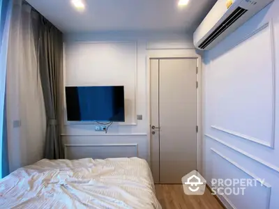 Cozy modern bedroom with a large comfortable bed, sleek flat-screen TV, and efficient air conditioning, perfect for relaxation.