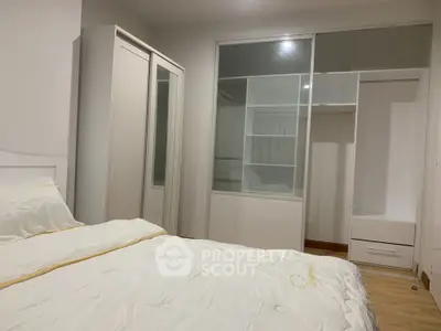 Spacious bedroom with modern wardrobe and cozy bedding, perfect for relaxation and comfort.