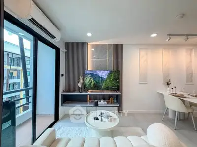 Modern living room with balcony view, stylish decor, and natural light in a contemporary apartment.