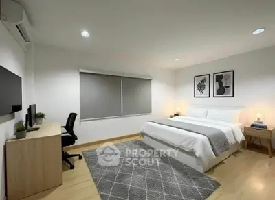 Modern bedroom with stylish decor, featuring a cozy bed, desk, and elegant lighting.