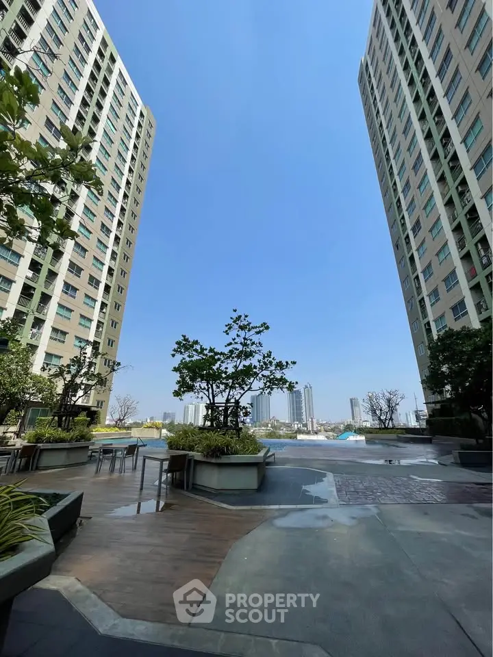 Stunning view of modern high-rise buildings with lush greenery and open sky, perfect for urban living.