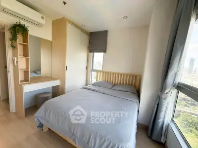 Bright and cozy bedroom with large windows offering city views, featuring modern furnishings and ample storage.