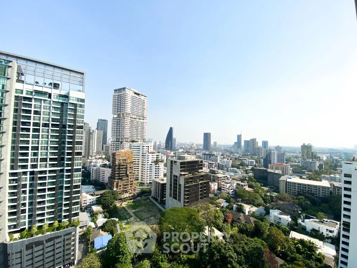 Stunning cityscape view from high-rise building showcasing urban skyline and lush greenery.