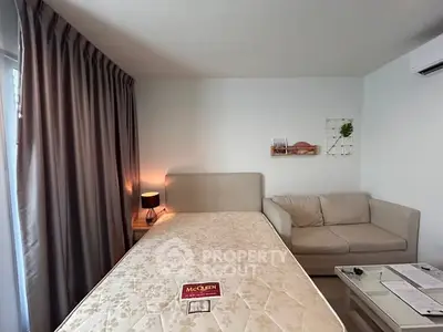 Cozy bedroom with modern decor, featuring a comfortable bed and stylish sofa.