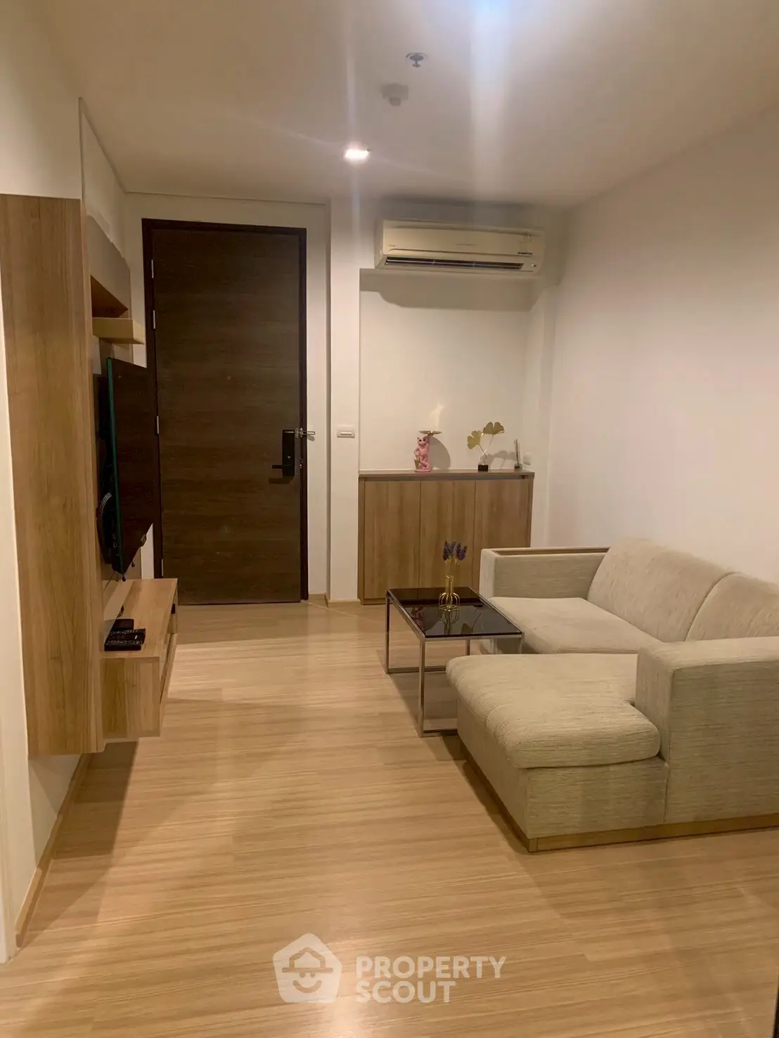 Modern living room with sleek wooden flooring and stylish furniture