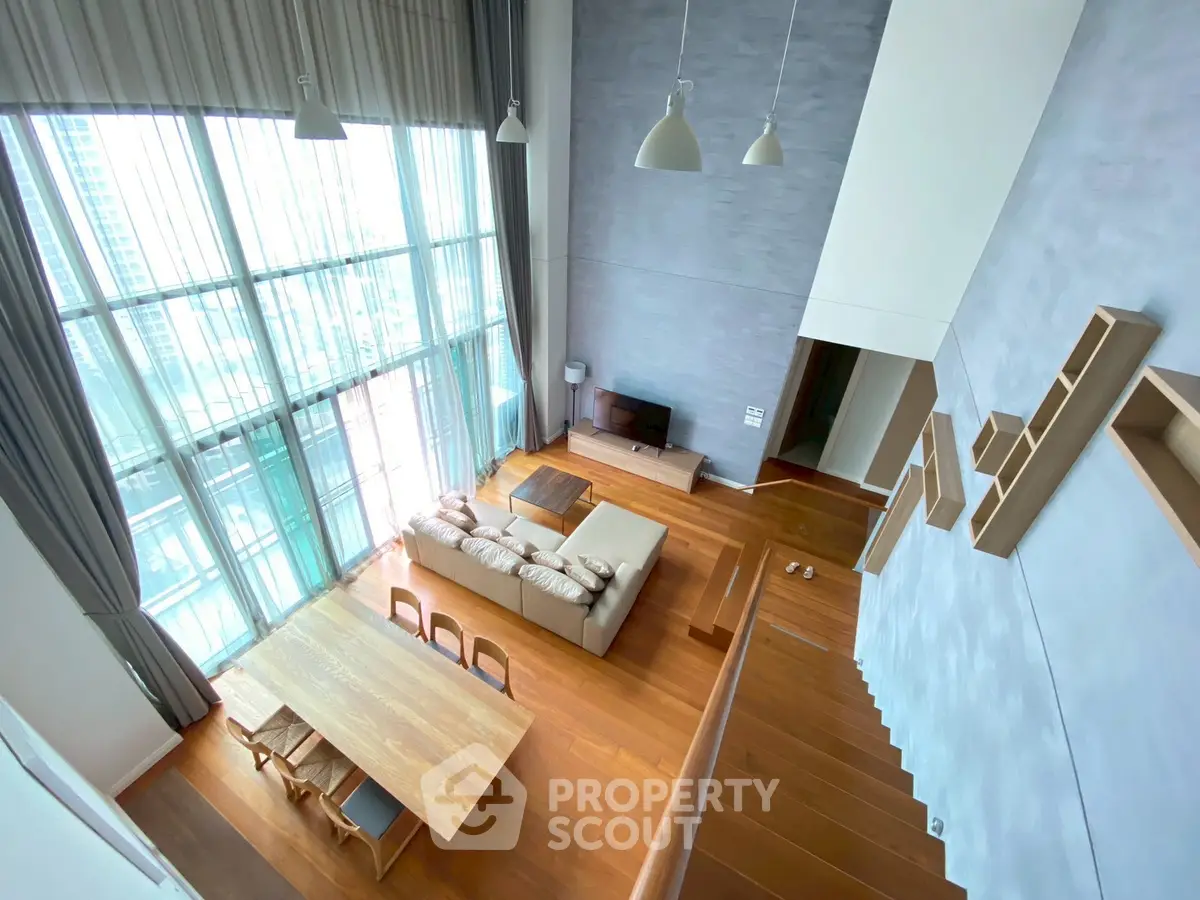Stunning high-ceiling living room with floor-to-ceiling windows and modern decor
