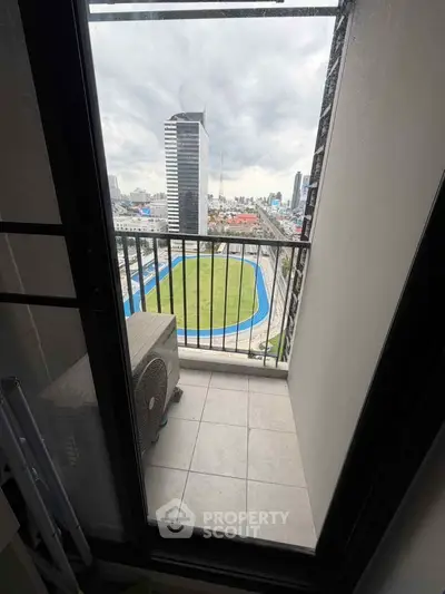 Compact balcony with city view overlooking a sports track, ideal for urban living.