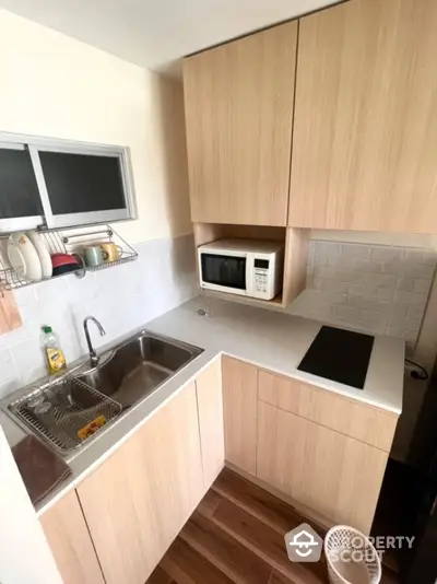 Modern compact kitchen with wooden cabinets and sleek appliances