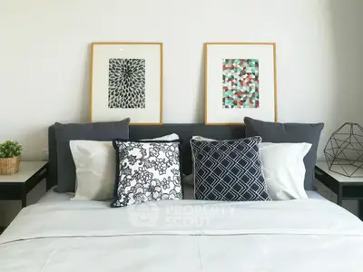 Modern bedroom with stylish decor and geometric artwork above bed