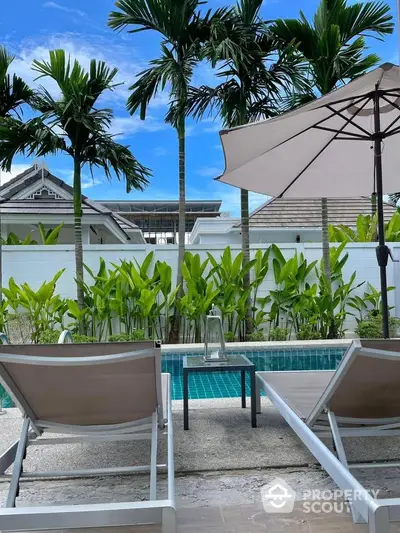 Luxurious poolside view with palm trees and sun loungers in a tropical paradise