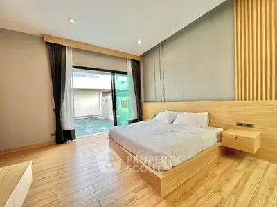 Spacious modern bedroom with wooden flooring and pool view