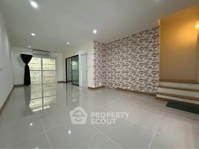 Spacious modern living room with brick accent wall and glossy tiled floor