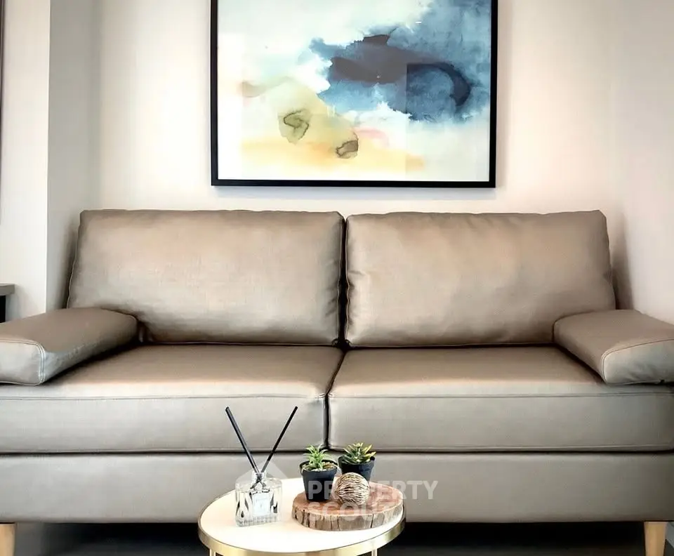 Modern living room with stylish sofa and abstract art, perfect for cozy relaxation.
