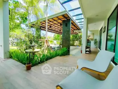 Luxurious garden view from modern patio with stylish seating and lush greenery.