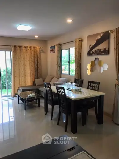 Spacious living room with elegant dining area and garden view, perfect for family gatherings.